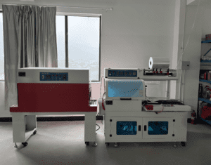 Two industrial shrink wrap machines in a warehouse setting.