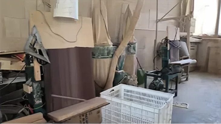 Messy woodworking workshop with tools, materials, and unfinished projects.